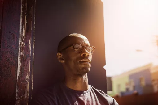 Thoughtful man leaning on wall in city