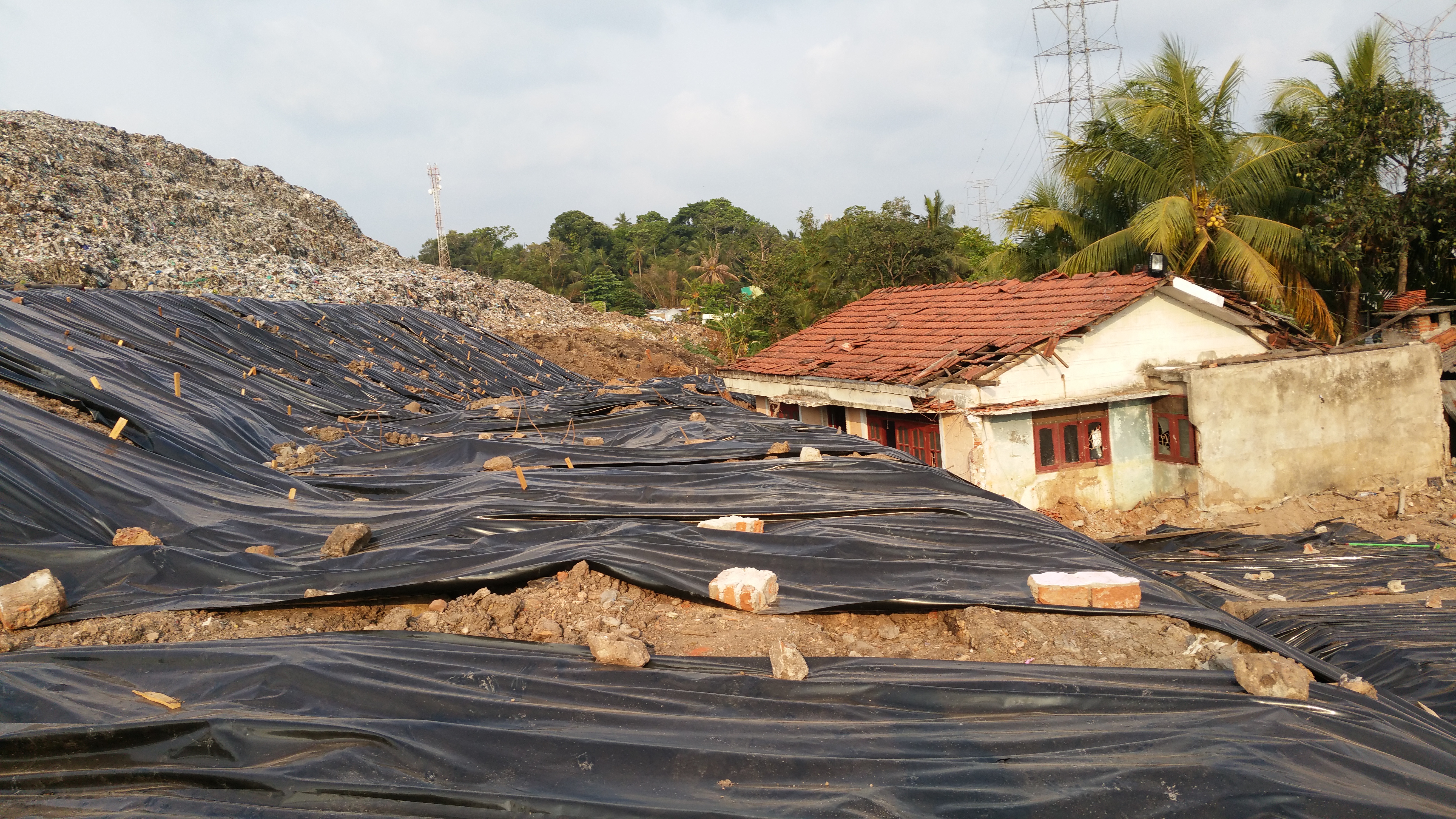 Black tarp coverings piles of trash